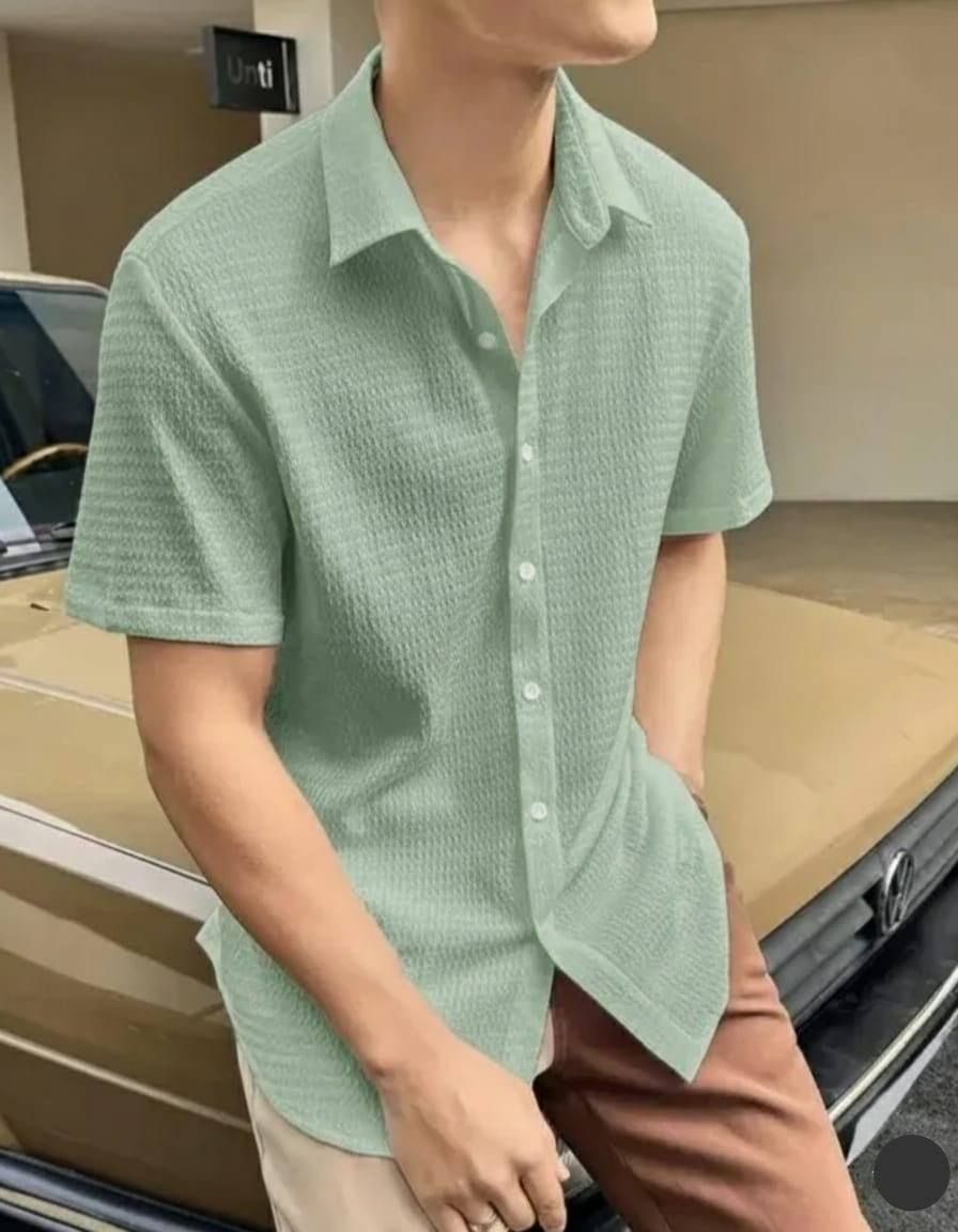 Person wearing a light green textured shirt in an indoor setting